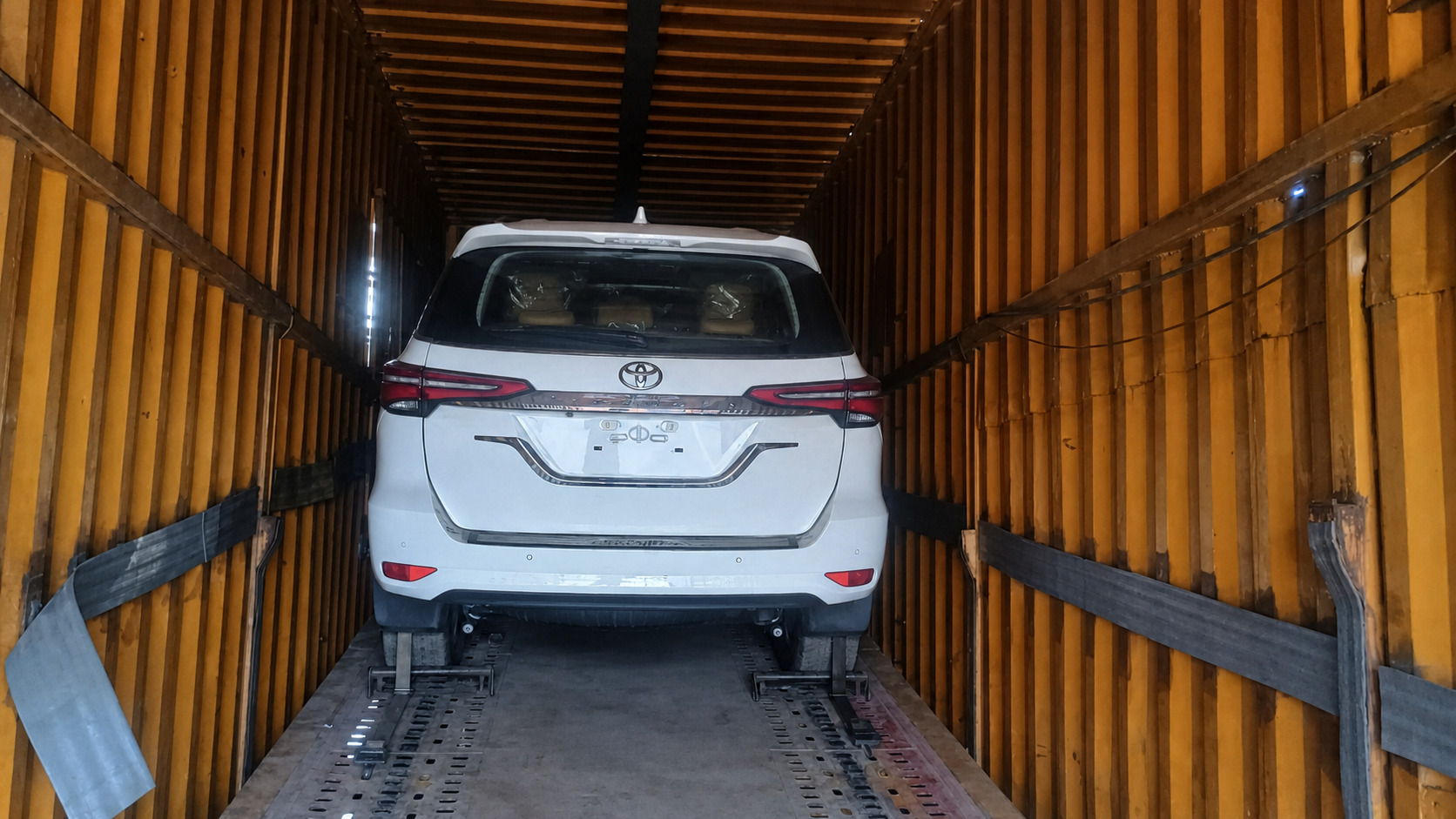 A brand-new Fortuner, seat covers still on, loaded for dealer delivery.