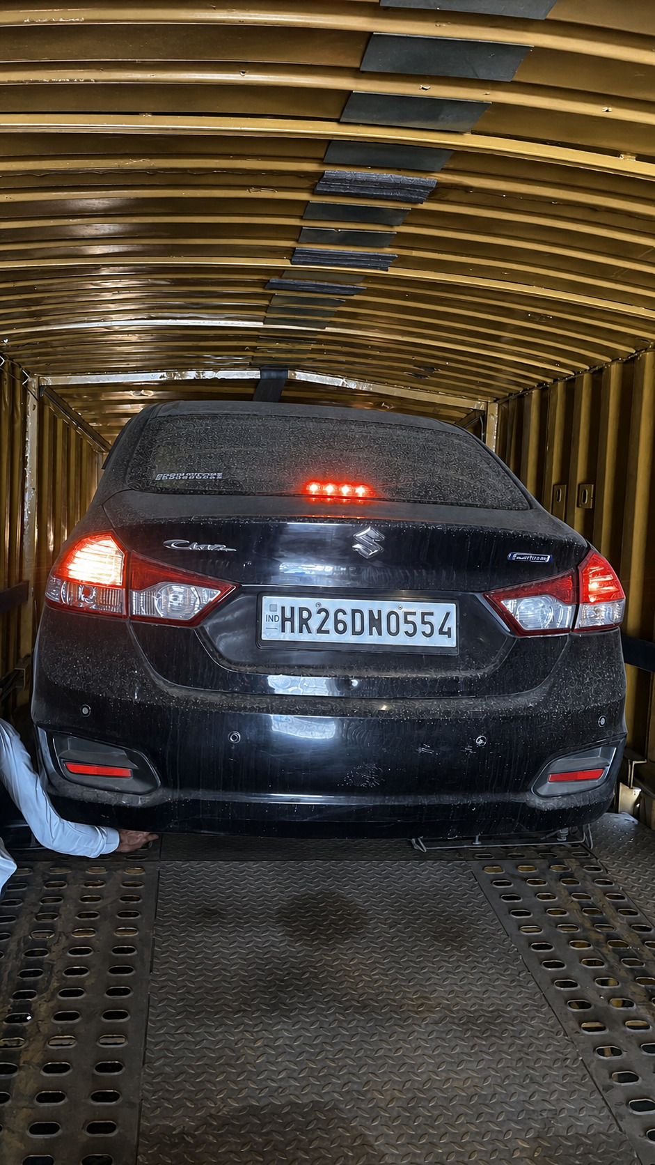 Chocking the wheel on a Maruti Ciaz before the straps go on.