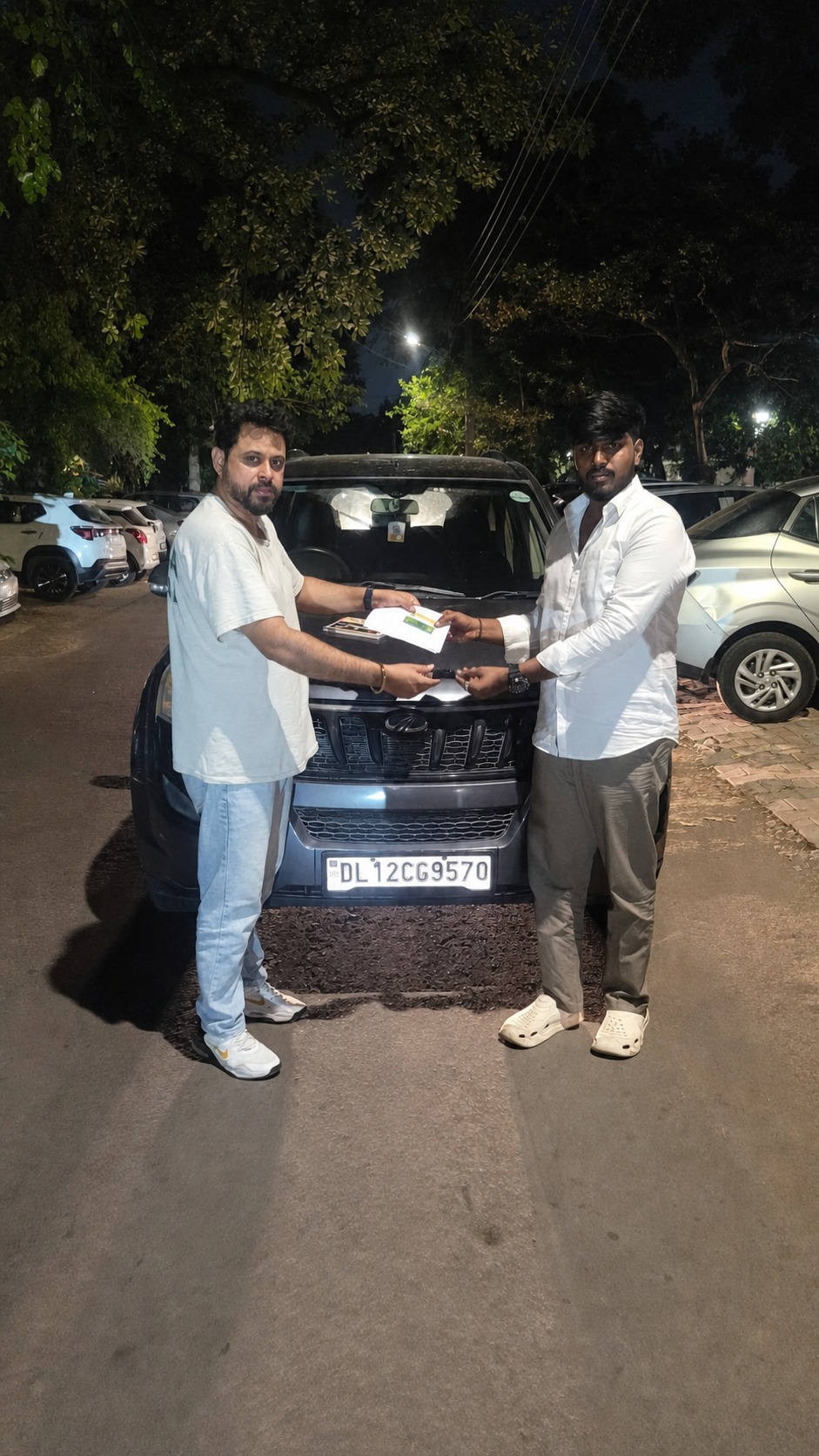 Papers and keys changing hands - another SUV delivered after dark.