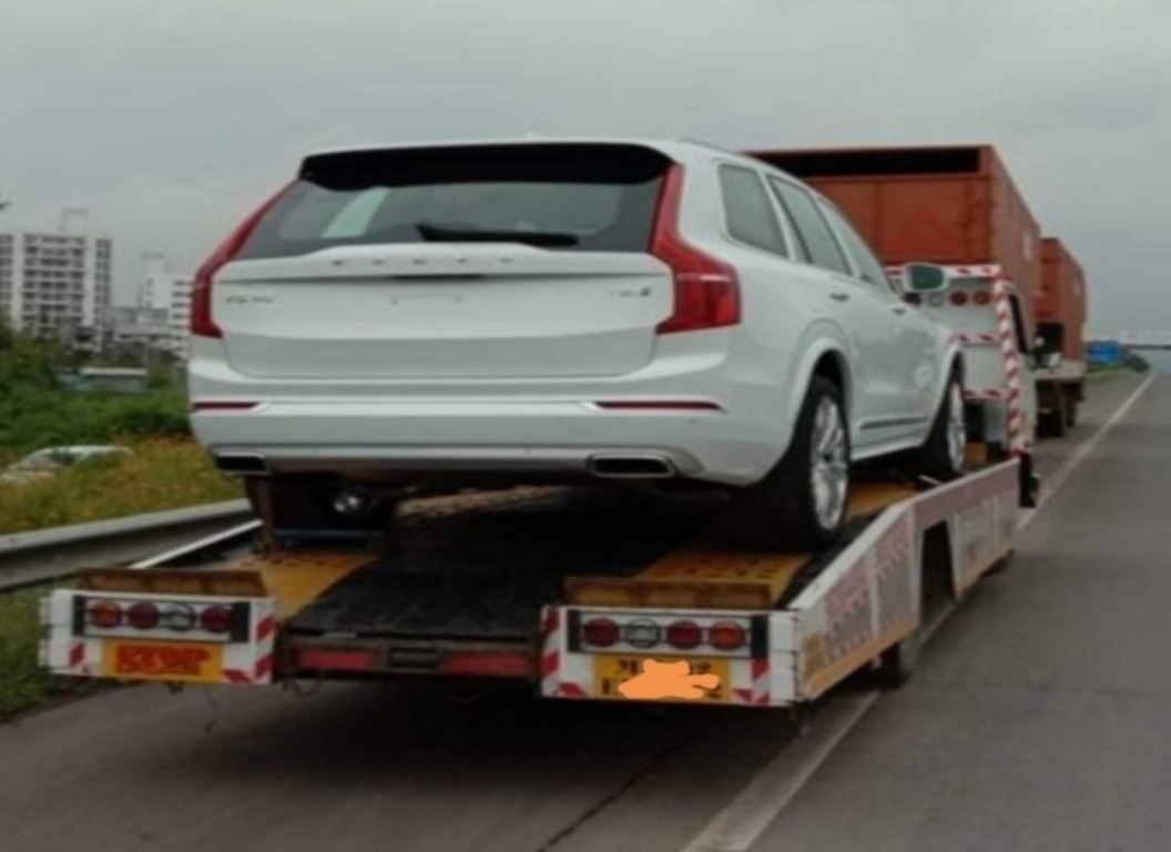 A white car is on the truck carrier for transport by Abhi Car Transport in Gurgaon from Gurgaon to Bangalore